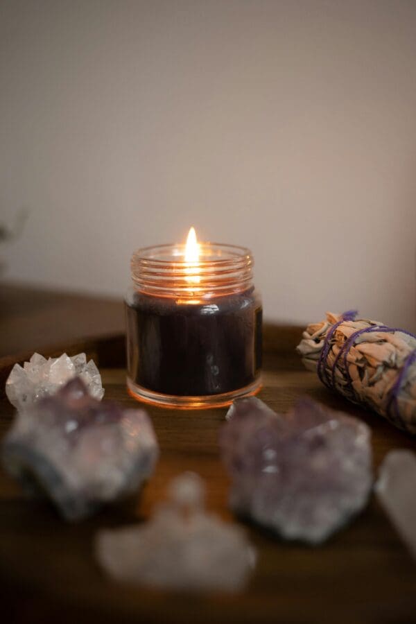 A candle lit in front of some rocks